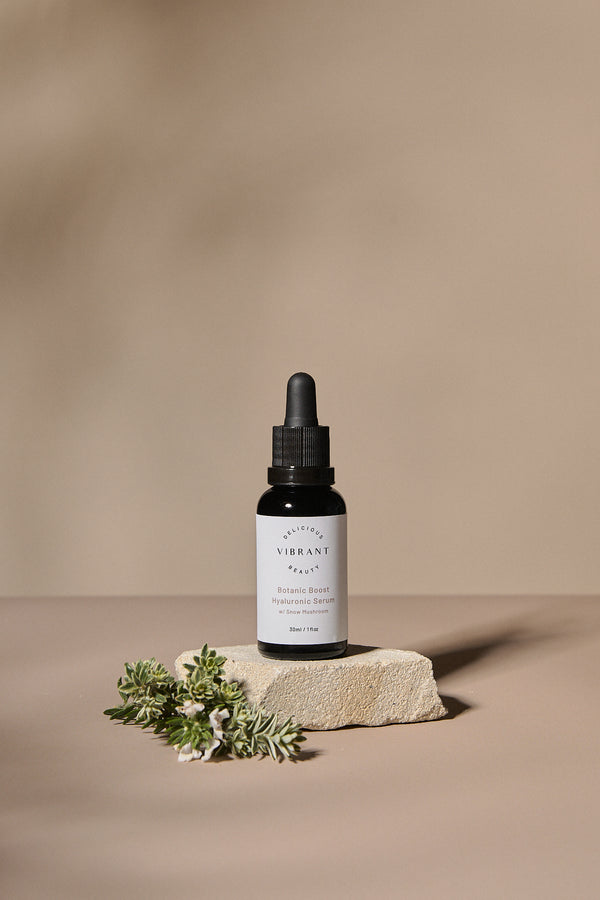 Botanic Boost Hyaluronic Serum dropper bottle with white label on a beige background