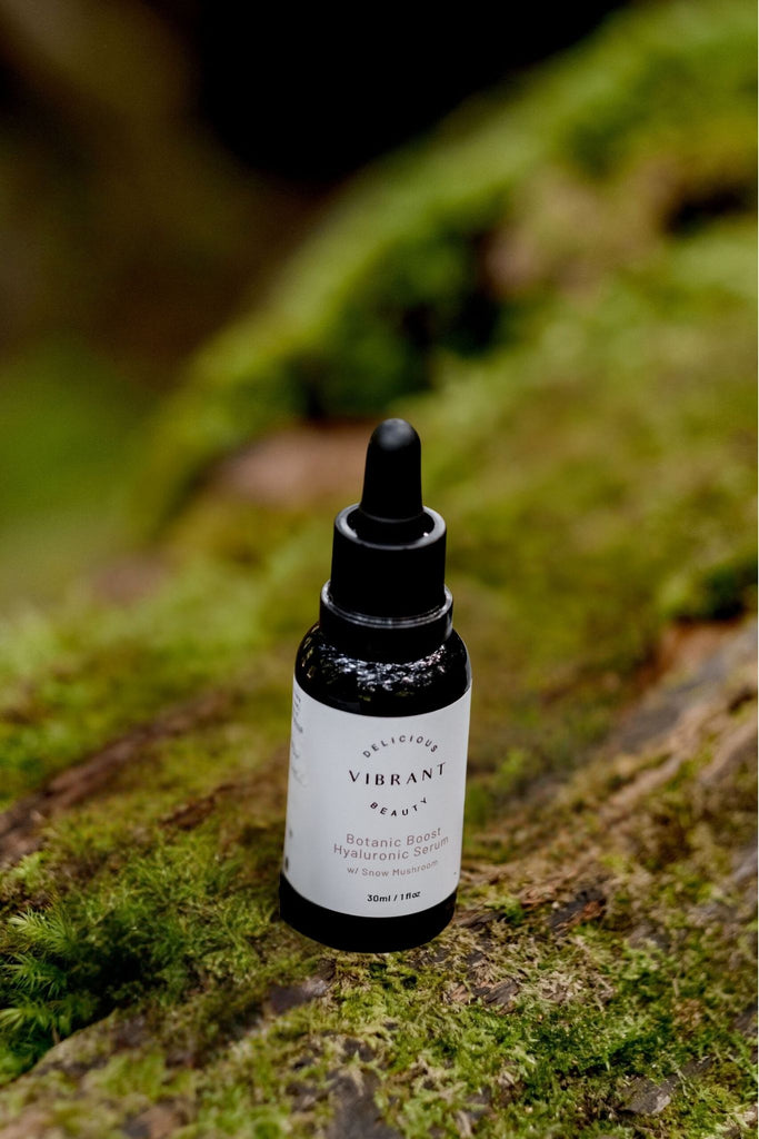 Bottle of Botanic Boost Hyaluronic Serum product on a mossy surface