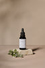 Black dropper bottle with white label on a beige background