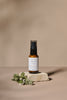 Cucumber Eye Balm bottle with a label on a beige background