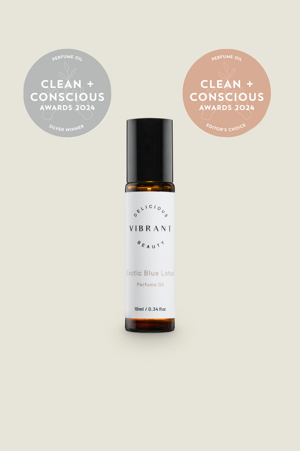 A small roller bottle of Blue Lotus Perfume Oil with labels indicating it is clean, conscious award winning. The bottle is amber-coloured with a white label.