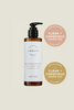 Bottle of 'Delicious Vibrant Beauty' cleansing cream with awards on a beige background