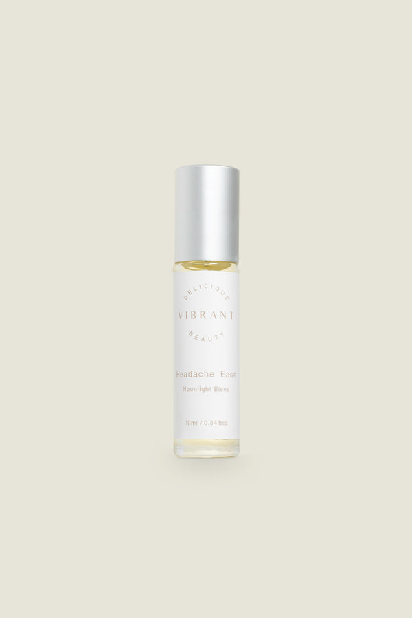 A clear roller bottle of Headache Ease essential oil blend with a white cap, labeled with the product name and branding.