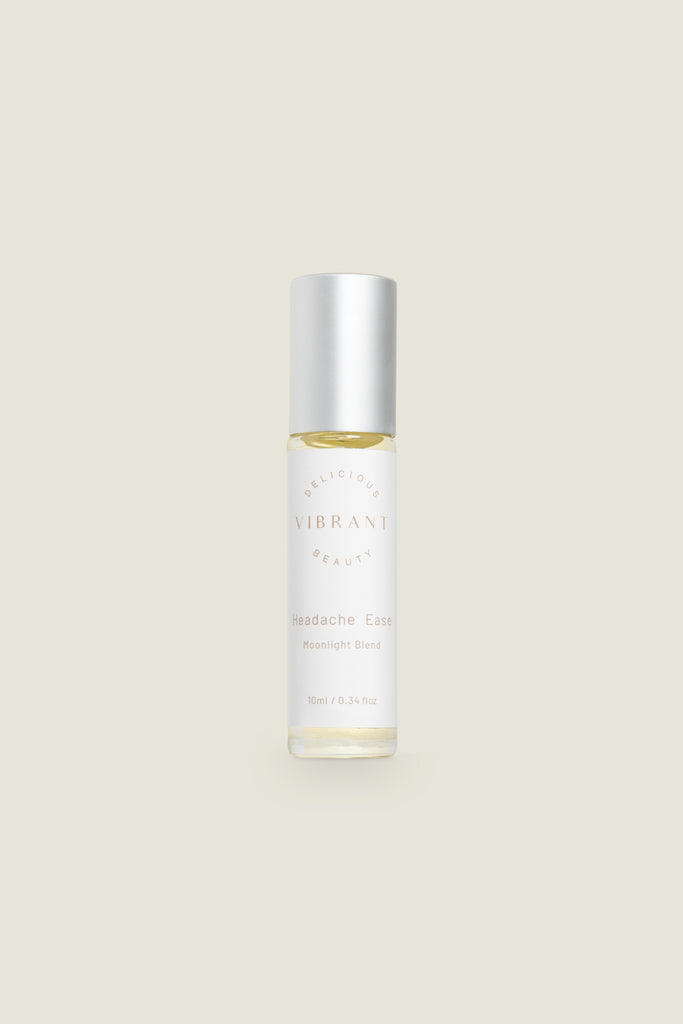 A clear roller bottle of Headache Ease essential oil blend with a white cap, labeled with the product name and branding.