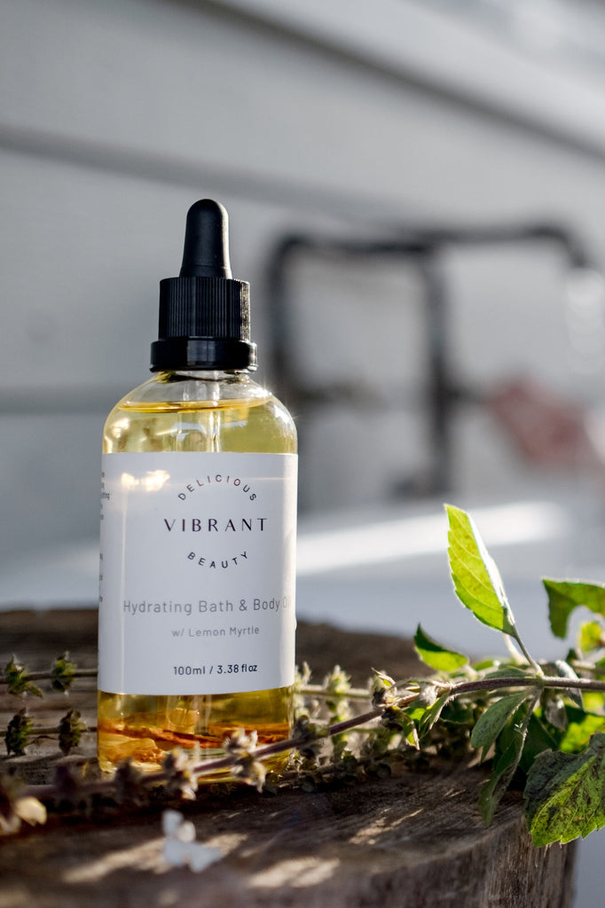Bottle of 'Delicious Vibrant Beauty ' skincare product on a wooden surface with blurred background