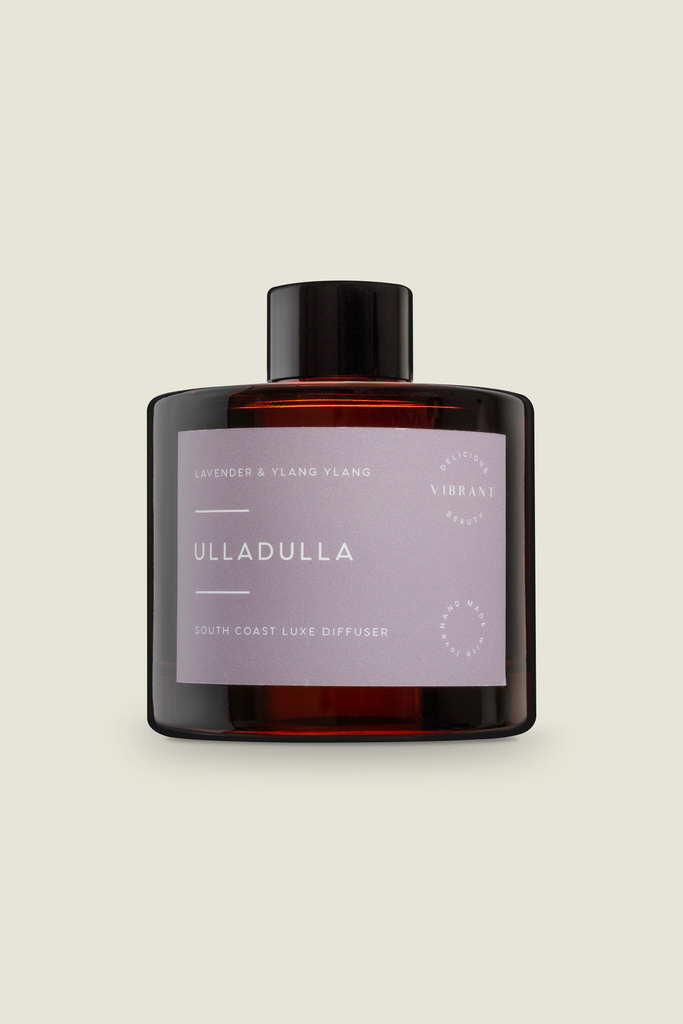 An amber reed diffuser bottle with a black cap, labeled 'Ulladulla', with Lavender & Ylang Ylang