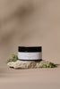 Jar of Luxe Rose body butter on a stone surface with a natural background