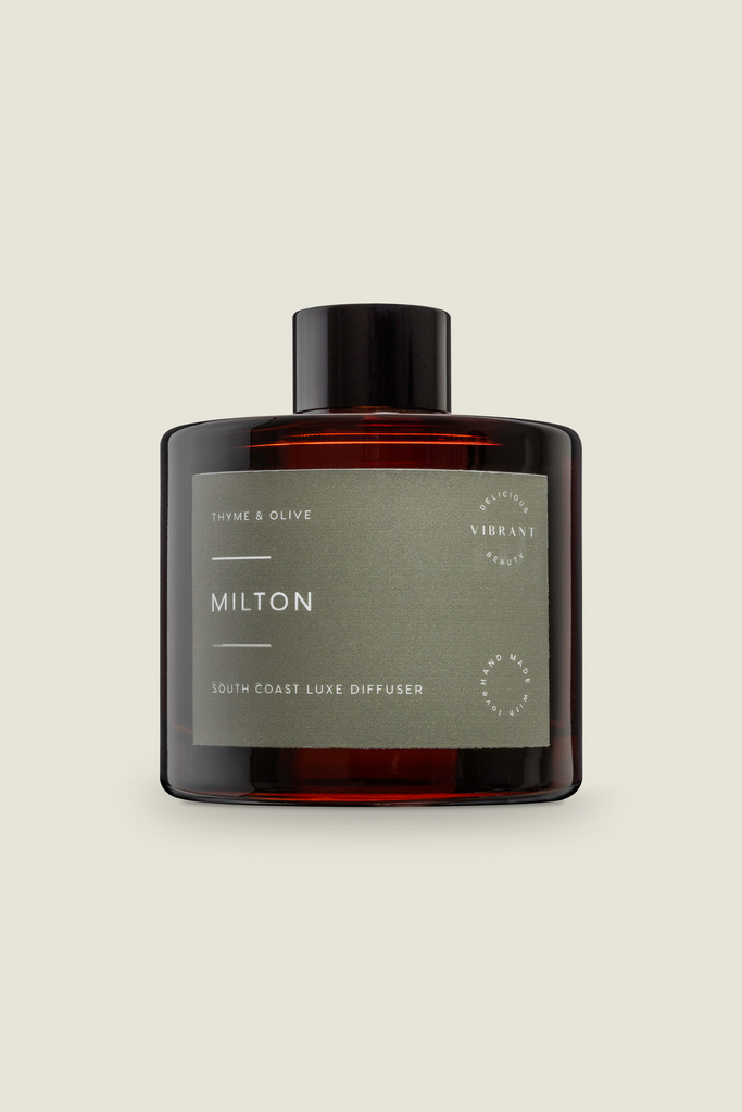 A brown glass reed diffuser bottle with a green label, titled 'Milton' and describing the scent as 'Thyme and Olive Leaf'.