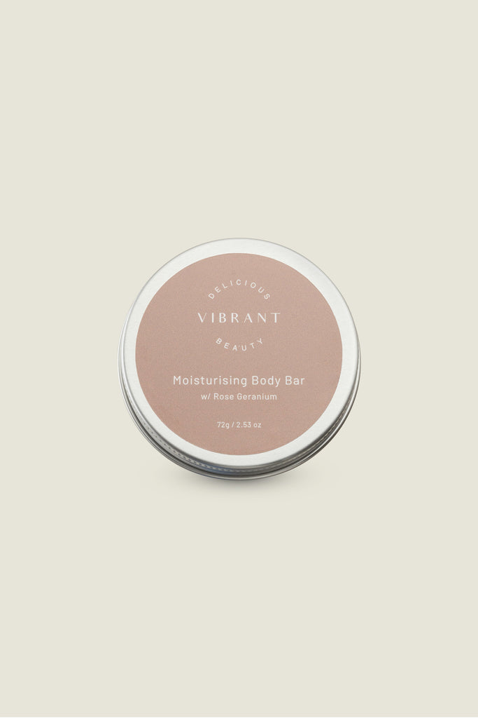 A solid moisturizing body bar in a tin container with a label on the lid. The label has text indicating that it is a moisturizing body bar with rose fragrance.
