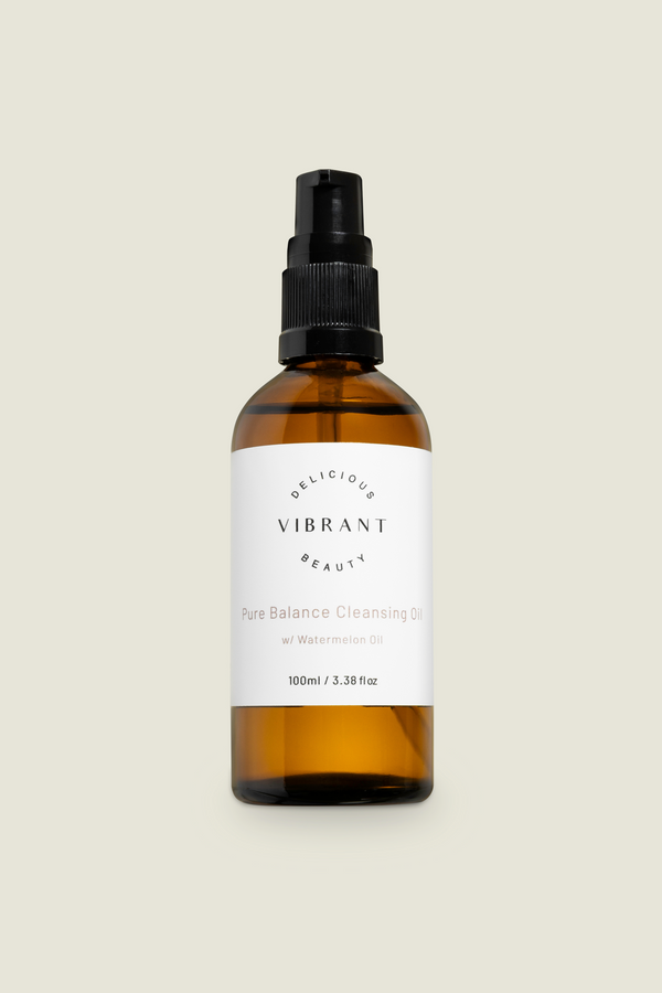 A clear glass bottle with a black spray nozzle, labelled 'DELICIOUS VIBRANT BEAUTY Pure Balance Cleansing Oil'.