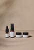 Set of Delicious Vibrant Beauty mini sized skincare products including bottles and jars on a beige background